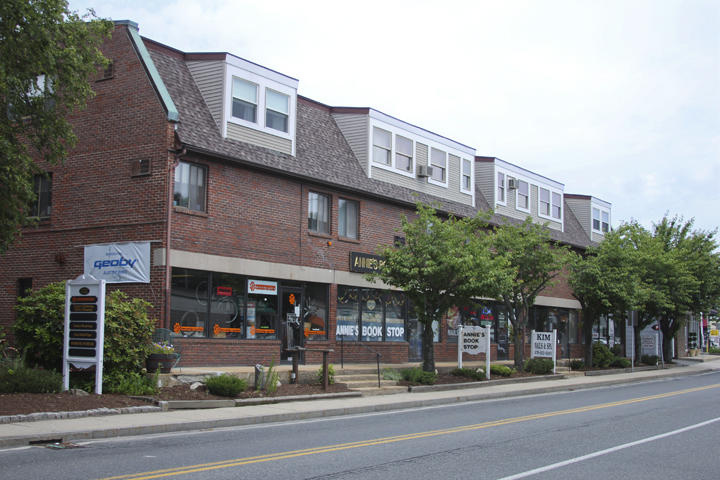 Brick mixed-use building with shops at street level and dormers above