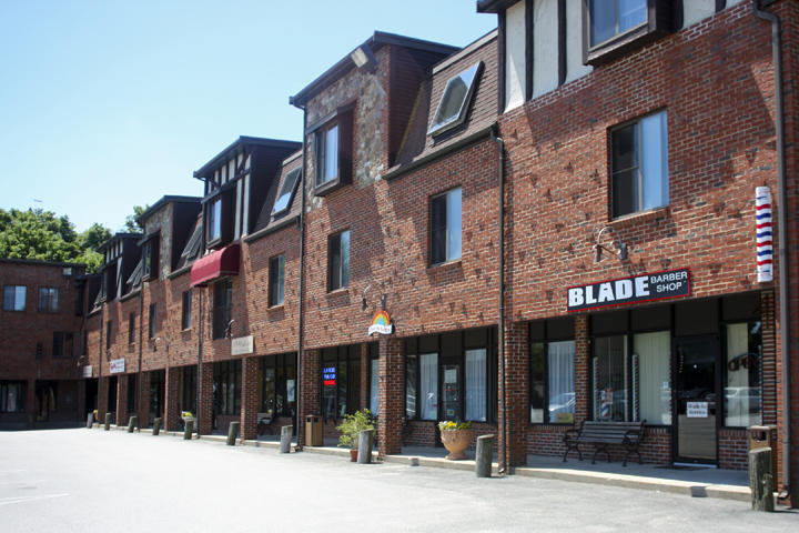 Row of brick mixed-use buildings with storefronts and dormers
