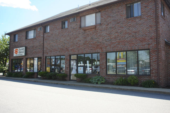 Two-story brick commercial building with large storefront windows